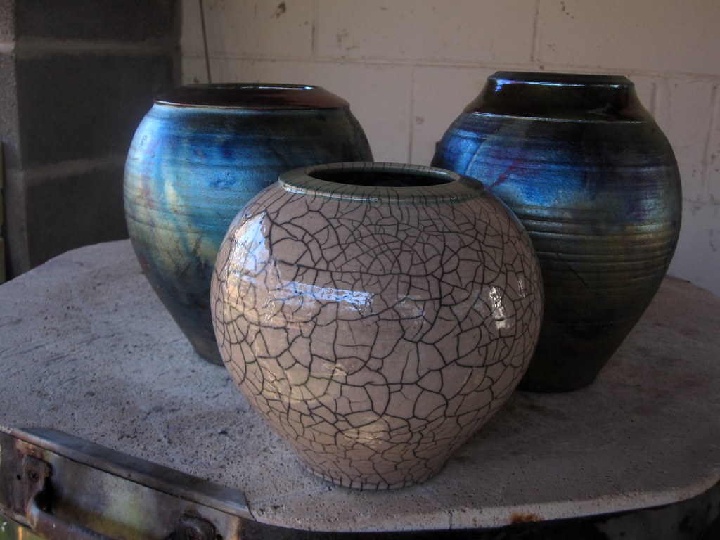 A tall dark, glossy glazed ceramic vessel.